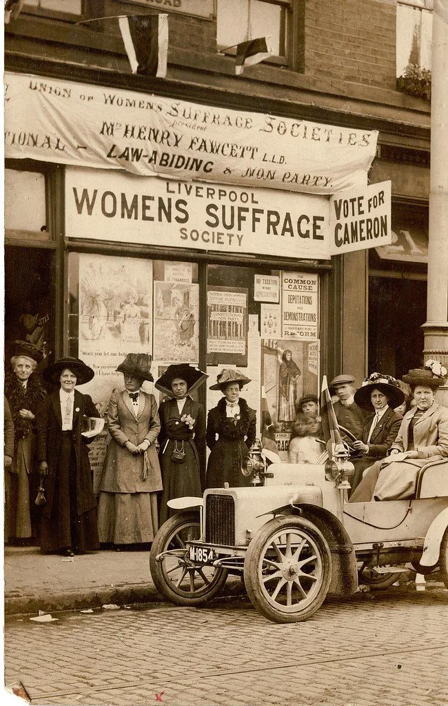 A historical photograph of suffragists marching.