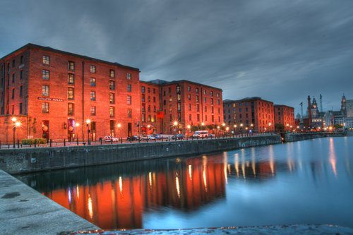 The Albert Dock in Liverpool illuminated at night.